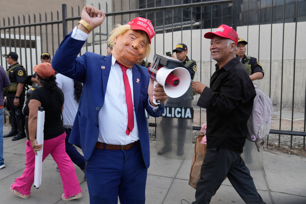 FILE - A man wearing a Donald Trump mask takes part in a rally of supporters for presidential candidate Rafael Lopez Aliaga in Lima, Peru, May 6, 2026. (AP Photo/Martin Mejia, File)