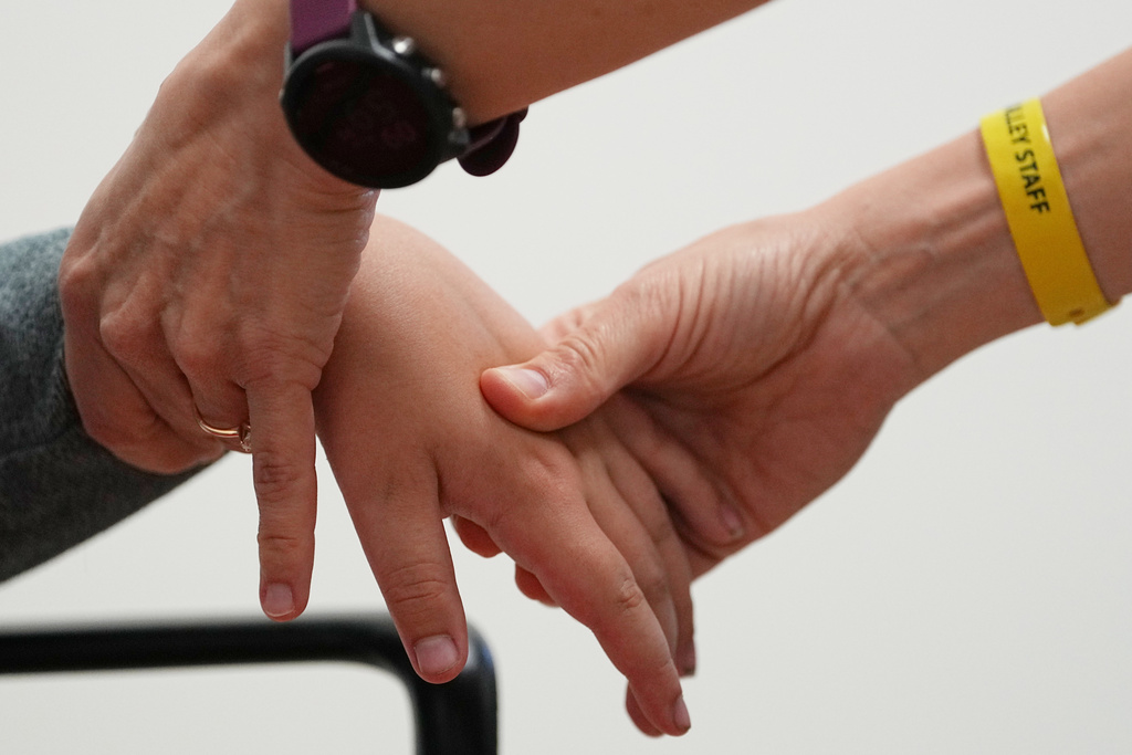 Dr. Natalia Vasquez-Canizares, right, examines Ethan Blanchfield-Killeen, 11, of Yonkers, N.Y., who has a form of juvenile idiopathic arthritis, at the Frost Valley YMCA sleepaway camp in Claryville, N.Y., Thursday, July 31, 2025. The camp partnered with Children's Hospital at Montefiore so kids with autoimmune diseases could attend for the first time. (AP Photo/Matt Rourke)