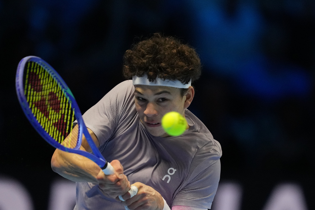United States' Ben Shelton returns the ball to Canada's Felix Auger-Aliassime during their tennis match of the ATP World Tour Finals, in Turin, Italy, Wednesday, Nov. 12, 2025. (AP Photo/Antonio Calanni)