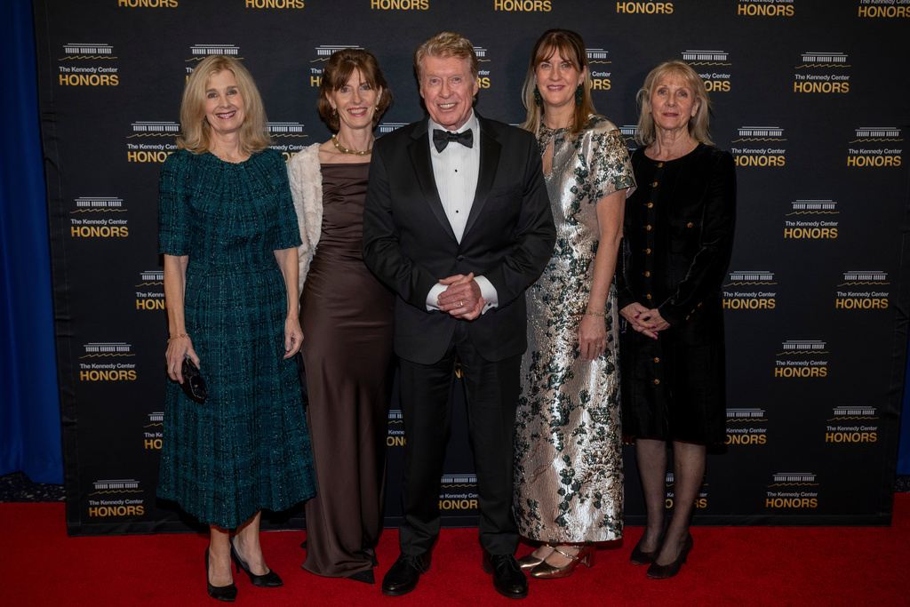 2025 Kennedy Center Honoree Michael Crawford, center, and his family arrive on the red carpet for the 48th Kennedy Center Honors Medallion Reception, hosted at the U.S. Department of State, Saturday, Dec. 6, 2025 in Washington. (AP Photo/Kevin Wolf)
