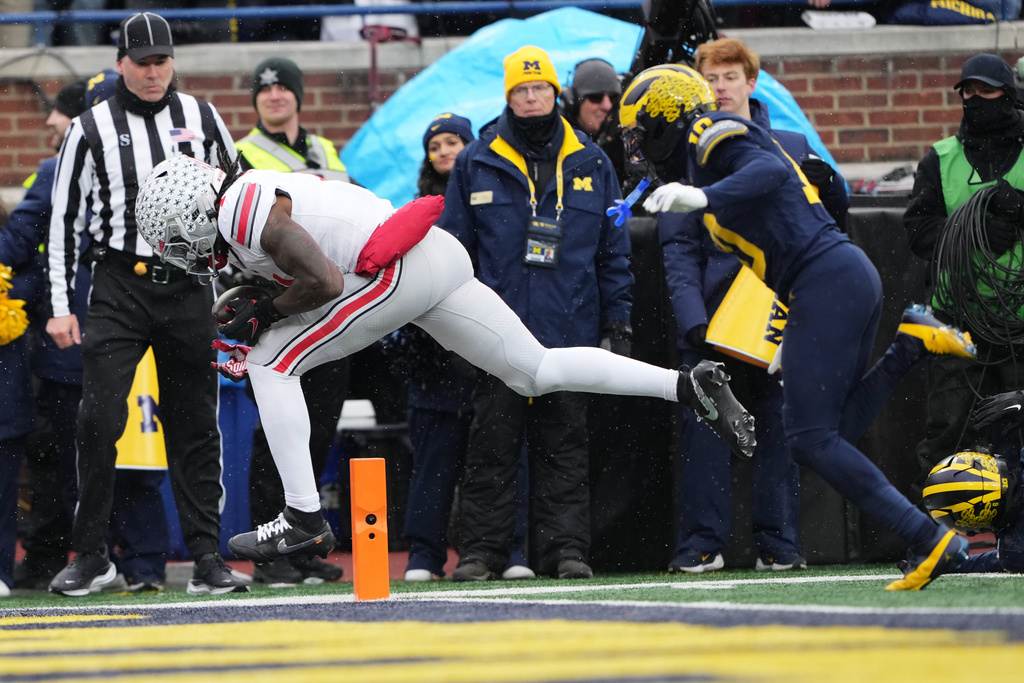 Ohio State wide receiver Jeremiah Smith, left, catches a pass for a touchdown against Michigan defensive back Zeke Berry during the first half of an NCAA college football game, Saturday, Nov. 29, 2025, in Ann Arbor, Mich. (AP Photo/Ryan Sun)