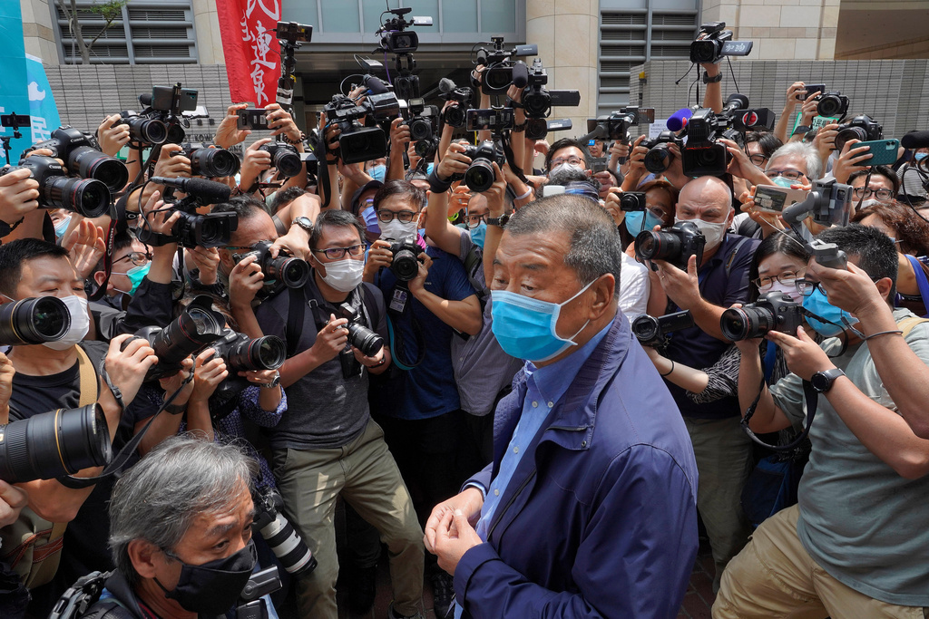 FILE - Hong Kong media tycoon Jimmy Lai, center, wearing a face mask arrives at court for charges relating to unlawful protests in Hong Kong, May 18, 2020. (AP Photo/Vincent Yu, File)