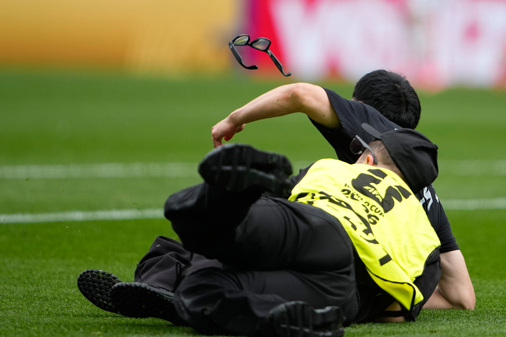 A pitch invader is held by security during the World Cup round of 32 soccer match between Belgium and Senegal in Seattle, Wednesday, July 1, 2026. (AP Photo/Lindsey Wasson)