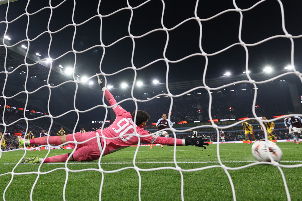 Maccabi Tel Aviv's goalkeeper Roi Mishpati dives but fails to save the goal from Aston Villa's Donyell Malen, centre, during the Europa League soccer match between Aston Villa and Maccabi Tel Aviv in Birmingham, England, Thursday, Nov. 6, 2025. (AP Photo/Darren Staples)