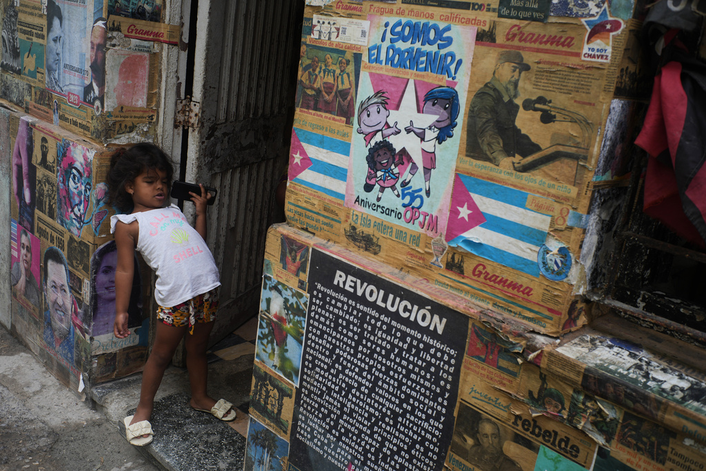 A girl plays in the doorway of the building where there is an art installation related to the Cuban Revolution, during a blackout in Havana, Tuesday, March 17, 2026. (AP Photo/Ramon Espinosa)