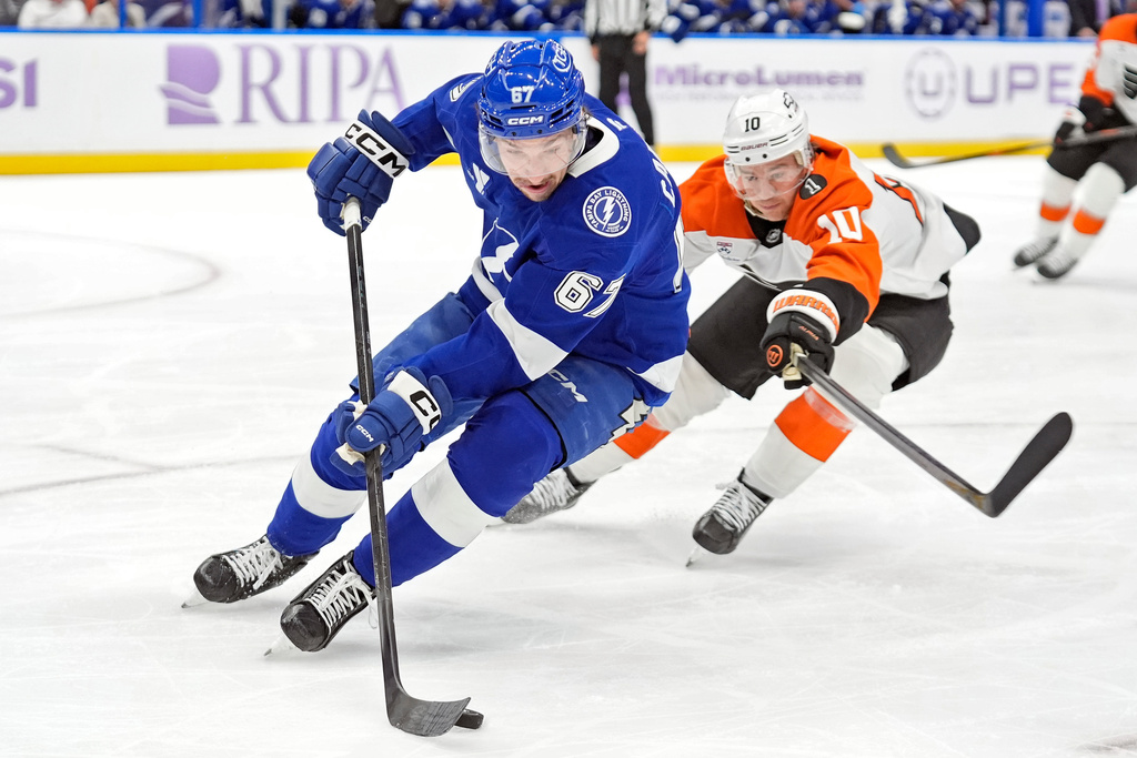 Tampa Bay Lightning defenseman Declan Carlile (67) cuts around Philadelphia Flyers right wing Bobby Brink (10) during the first period of an NHL hockey game Monday, Nov. 24, 2025, in Tampa, Fla. (AP Photo/Chris O'Meara)