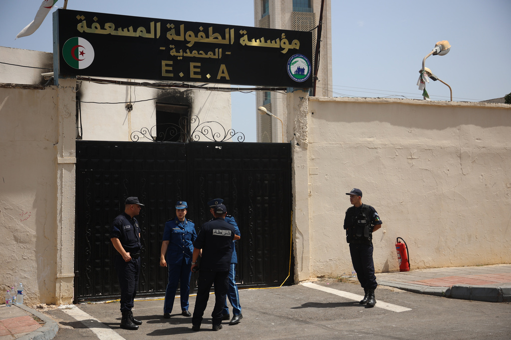 Policemen stand outside the fire damaged orphanage in Mohammedia, near Algiers, Algeria, Thursday, July 16, 2026. (AP Photo)