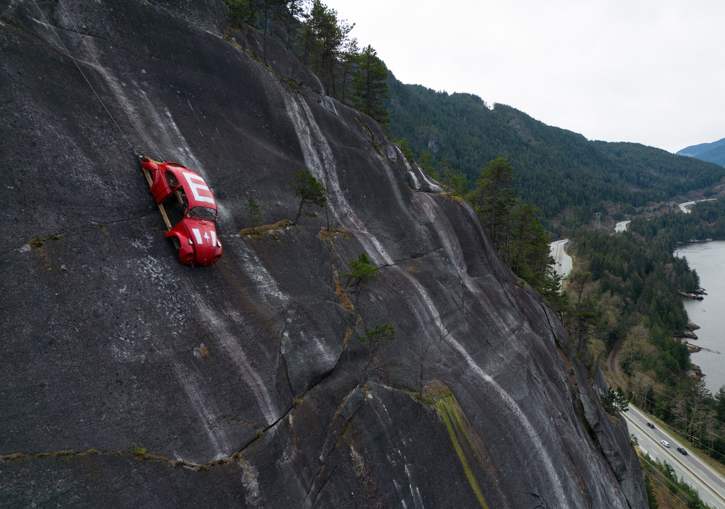 The shell of a Volkswagen Beetle hangs suspended on a cliff above the Sea-to-Sky Highway, in Squamish, British Columbia, Monday, April 6, 2026, after it appeared on the rock face last week with a large "E" on its roof, indicating that University of British Columbia engineering students carried out a long-standing tradition of placing the shell in difficult to reach locations. (Darryl Dyck/The Canadian Press via AP)