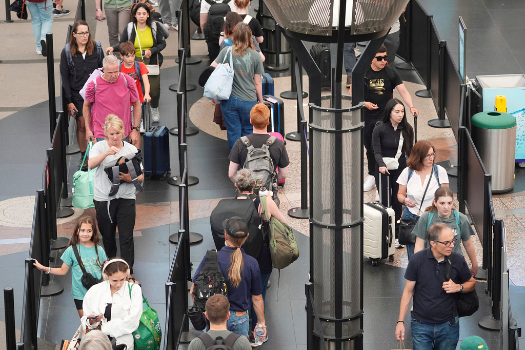 FILE -Travelers queue up to pass through the south security checkpoint in Denver International Airport Wednesday, July 2, 2025, in Denver. (AP Photo/David Zalubowski, File)