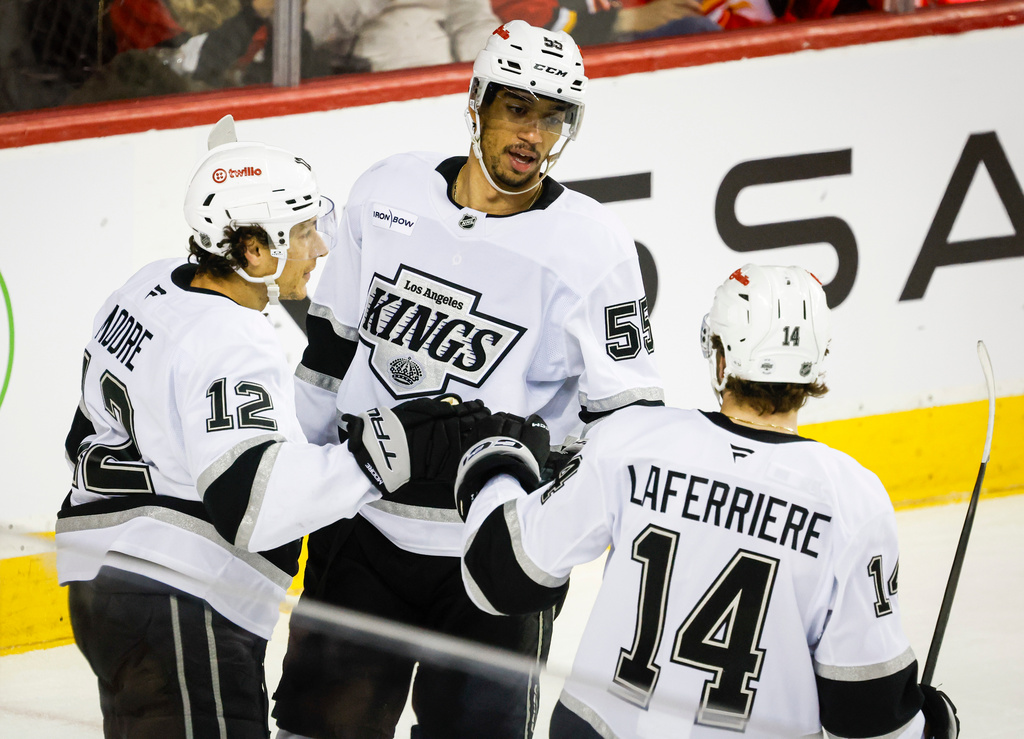 Los Angeles Kings' Quinton Byfield, centre, celebrates his goal with teammates Trevor Moore, left, and Alex Laferriere during the second period of an NHL hockey game against the Calgary Flames in Calgary on Thursday, April 16, 2026. (Jeff McIntosh/The Canadian Press via AP)