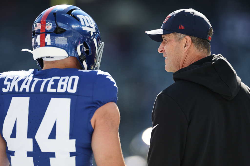 New York Giants head coach John Harbaugh, right, talks with Giants running back Cam Skattebo (44) ahead of an NFL football game against the New Orleans Saints in East Rutherford, N.J., Sunday, Oct. 18, 2026. (AP Photo/Adam Hunger)