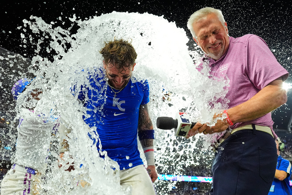Kansas City Royals' Carter Jensen with commentator Joel Goldberg are doused by teammates after their baseball game, Friday, July 17, 2026, in Kansas City, Mo. (AP Photo/Charlie Riedel)