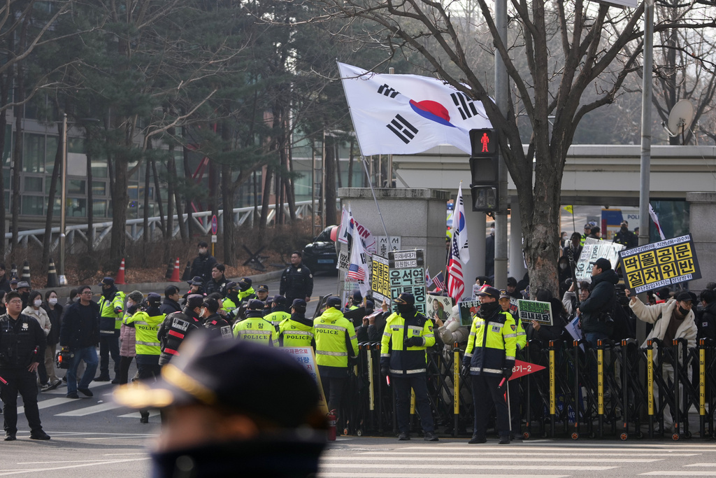 Supporters of former South Korean President Yoon Suk Yeol hold signs and flags outside Seoul Central District Court, in Seoul, South Korea, Friday, Jan. 16, 2026. (AP Photo/Lee Jin-man)