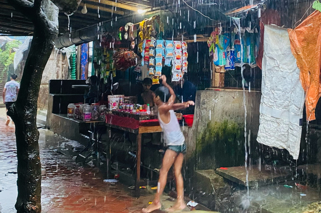 A child plays in heavy rain at a Rohingya refugee camp in Cox's Bazar, Bangladesh, Tuesday, July 7, 2026. (AP Photo/Shamimul Islam Faisal)