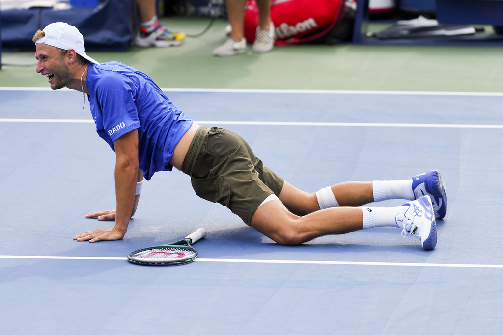 Leandro Riedi, of Switzerland, drops to the court after defeating Francisco Cerundolo, of Argentina, during the second round of the U.S. Open tennis championships, Thursday, Aug. 28, 2025, in New York. (AP Photo/Kirsty Wigglesworth)