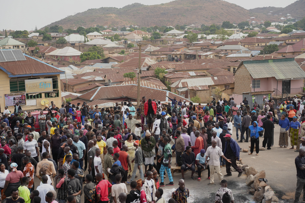 People gather at the scene of Sunday night gunmen attack in Gari Ya Waye community in the Jos North Nigeria, Monday, March 30, 2026. (AP Photo/Samson Omale)