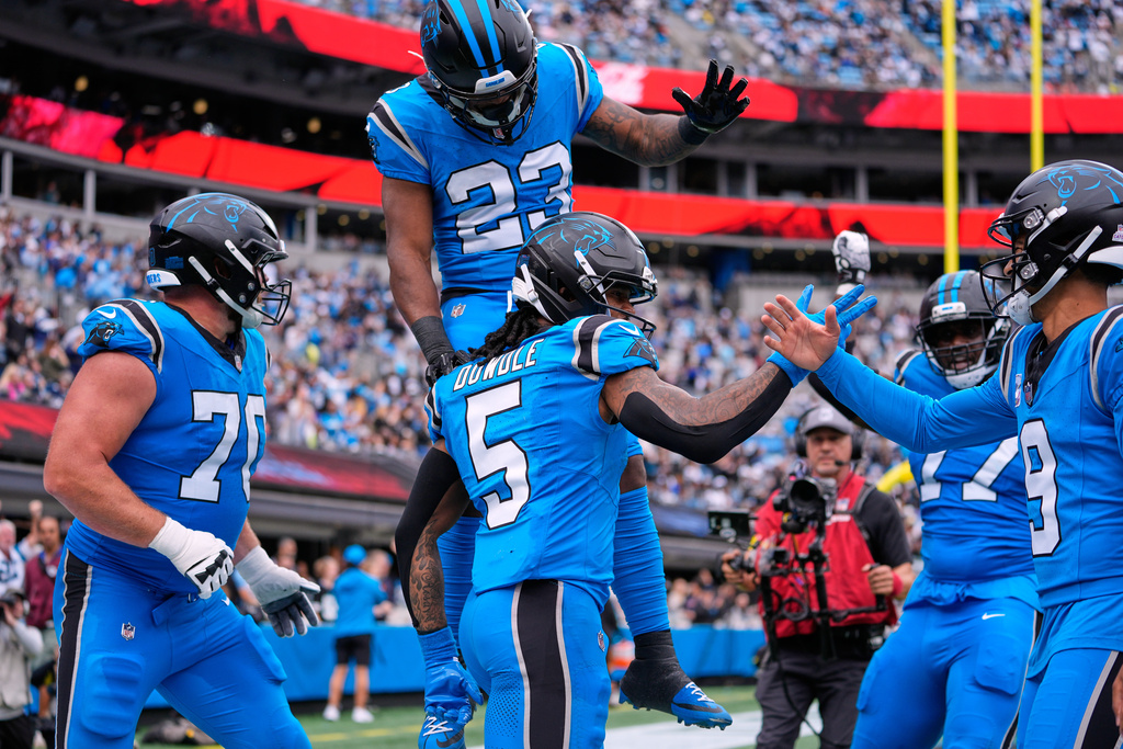 Carolina Panthers' Rico Dowdle (5) celebrates his touchdown run with Bryce Young (9), Brady Christensen (70) and Trevor Etienne (23) in the second half of an NFL football game against the Dallas Cowboys, Sunday, Oct. 12, 2025, in Charlotte, N.C. (AP Photo/Erik Verduzco)