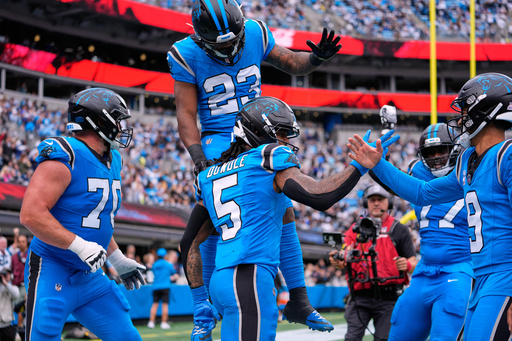 Carolina Panthers' Rico Dowdle (5) celebrates his touchdown run with Bryce Young (9), Brady Christensen (70) and Trevor Etienne (23) in the second half of an NFL football game against the Dallas Cowboys, Sunday, Oct. 12, 2025, in Charlotte, N.C. (AP Photo/Erik Verduzco) Carolina Panthers' Rico Dowdle (5) celebrates his touchdown run with Bryce Young (9), Brady Christensen (70) and Trevor Etienne (23) in the second half of an NFL football game against the Dallas Cowboys, Sunday, Oct. 12, 2025, in Charlotte, N.C. (AP Photo/Erik Verduzco)