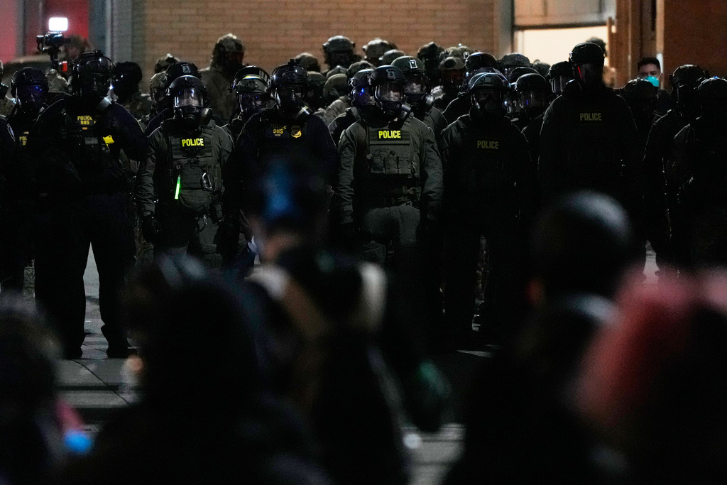 Law enforcement officers standoff against demonstrators outside a U.S. Immigration and Customs Enforcement facility during a protest on Saturday, Oct. 4, 2025, in Portland, Ore. (AP Photo/Jenny Kane)