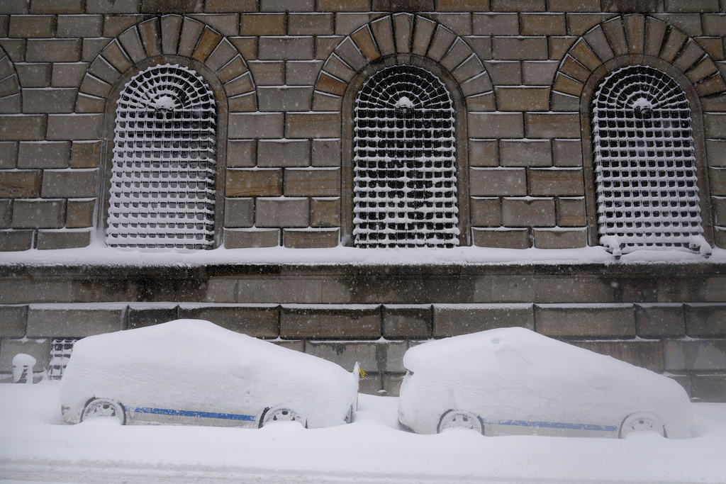 City vehicles sit parked covered in snow in lower Manhattan during a snow storm, Monday, Feb. 23, 2026, in New York. (AP Photo/Seth Wenig)