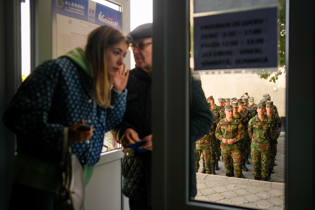 Soldiers wait outside a voting stations to cast their vote during a parliamentary election, in Chisinau, Moldova, Sunday, Sept. 28, 2025. (AP Photo/Vadim Ghirda)