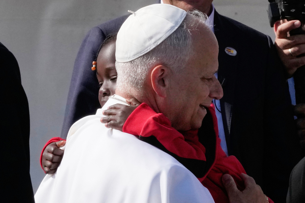 Pope Leo XIV hug a child during a meeting with migrants at the 'Las Raices' center, in San Cristobal de la Laguna, Tenerife, Spain, Friday, June 12, 2026. (AP Photo/Alessandra Tarantino)