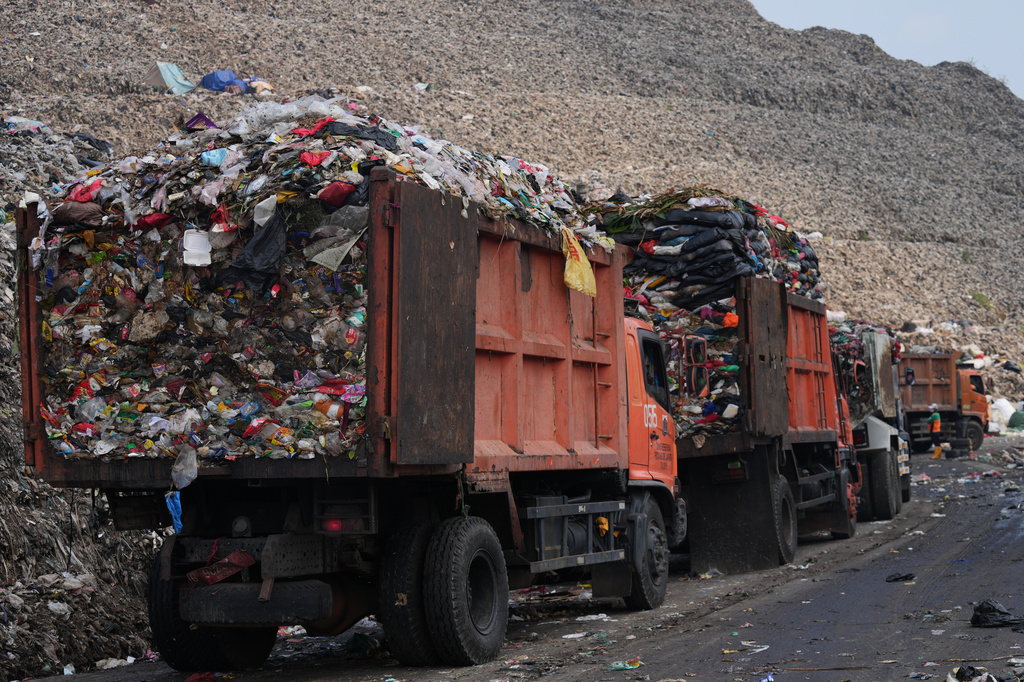 Garbage trucks line up before unloading waste at the Bantargebang landfill on the outskirts of Jakarta, Indonesia, Monday, July 6, 2026. (AP Photo/Tatan Syuflana)