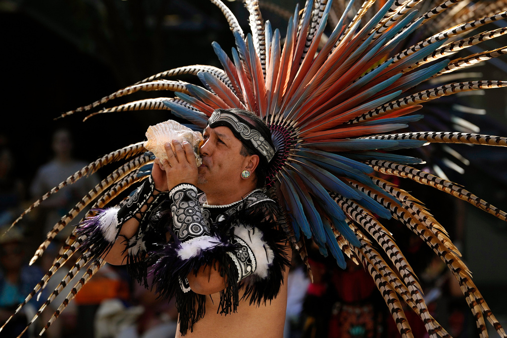 FILE - A member of the Grupo Coatlicue blows on a conch shell during a performance of a traditional Aztec dance, an agricultural prayer ceremony in motion, during an Indigenous Peoples' Day event, Oct. 14, 2024, in Phoenix. (AP Photo/Ross D. Franklin, File)