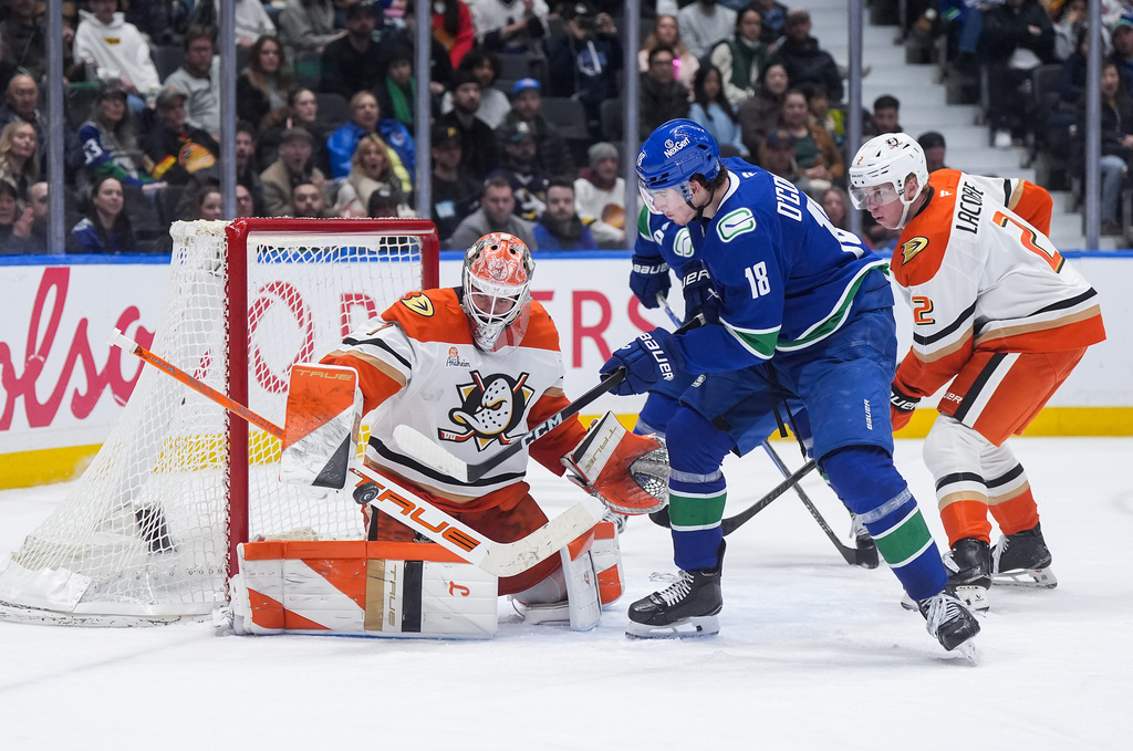 Anaheim Ducks goalie Lukas Dostal (1) stops Vancouver Canucks' Drew O'Connor (18) as Anaheim's Jackson LaCombe (2) watches during the third period of an NHL hockey game, in Vancouver, on Tuesday, March 24, 2026. (Darryl Dyck/The Canadian Press via AP)