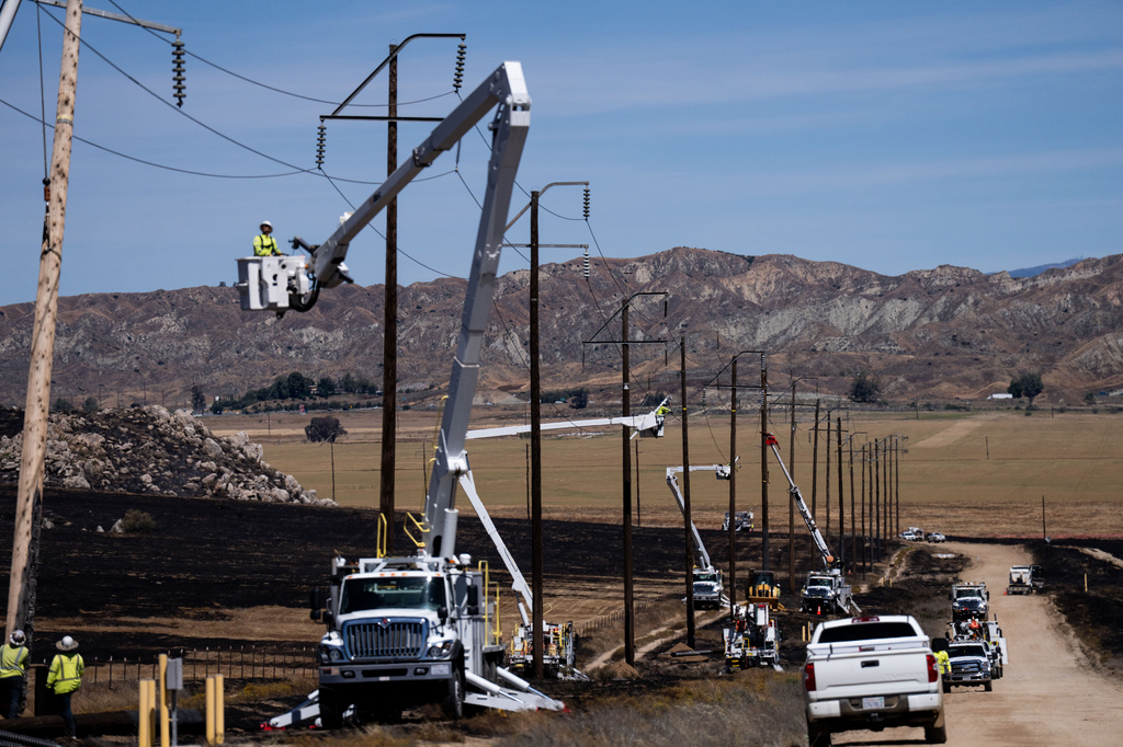 Utility crews work to restore power lines in an area burned by the Springs Fire in Moreno Valley, Calif., Saturday, April 4, 2026. (AP Photo/Jae C. Hong)