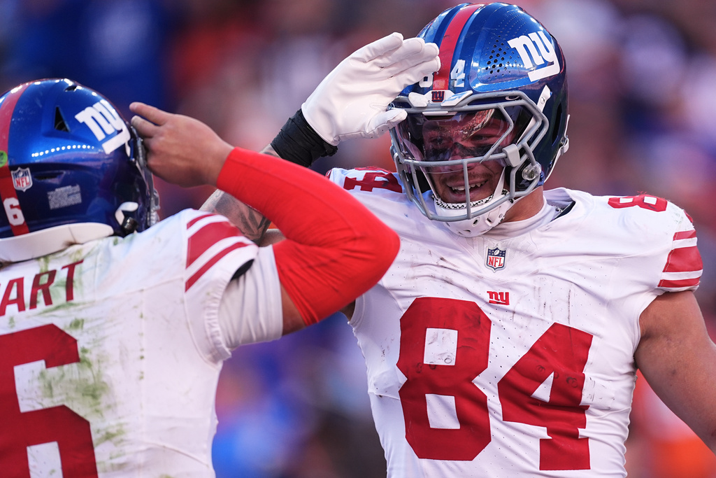 New York Giants tight end Theo Johnson (84) celebrates after catching a touchdown pass from quarterback Jaxson Dart, left, during the second half of an NFL football game against the Denver Broncos in Denver, Sunday, Oct. 19, 2025. (AP Photo/David Zalubowski)