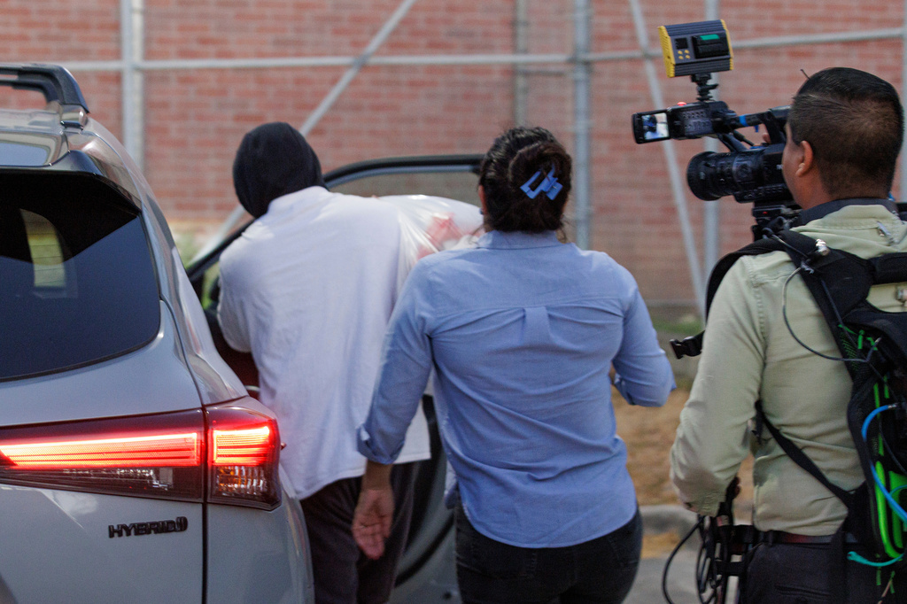 Immigration and Customs Enforcement officer Christian Castro gets into a car surrounded by news reporters moments after being released from the Carrizalez-Rucker Cameron County Detention Center in Brownsville, Texas on Thursday, Aug. 27, 2026. (AP Photo/Michael Gonzalez)