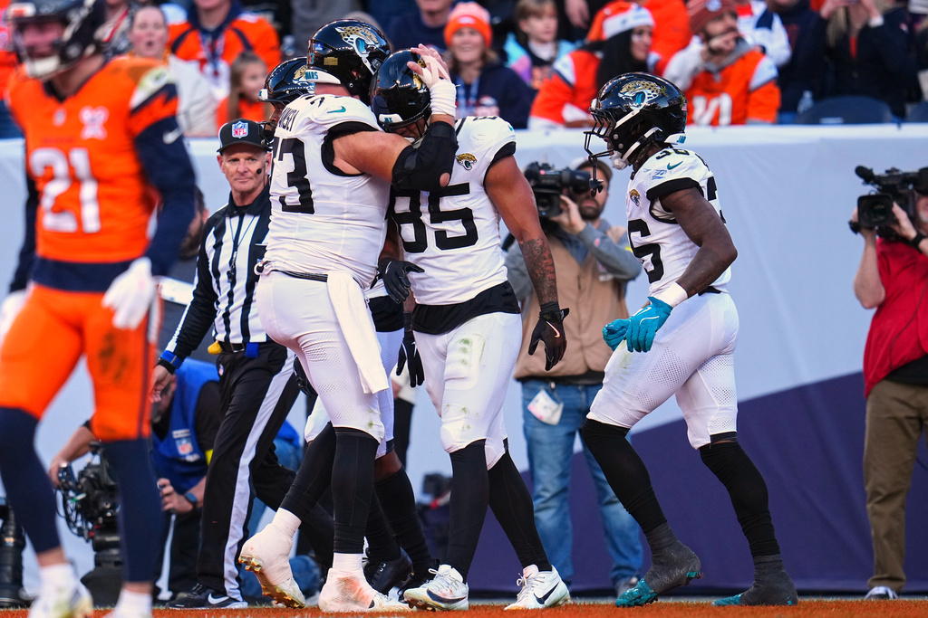Jacksonville Jaguars tight end Brenton Strange (85) celebrates with center Robert Hainsey (73) after scoring a touchdown against the Denver Broncos during the first half of an NFL football game in Denver, Sunday, Dec. 21, 2025. (AP Photo/Jack Dempsey)