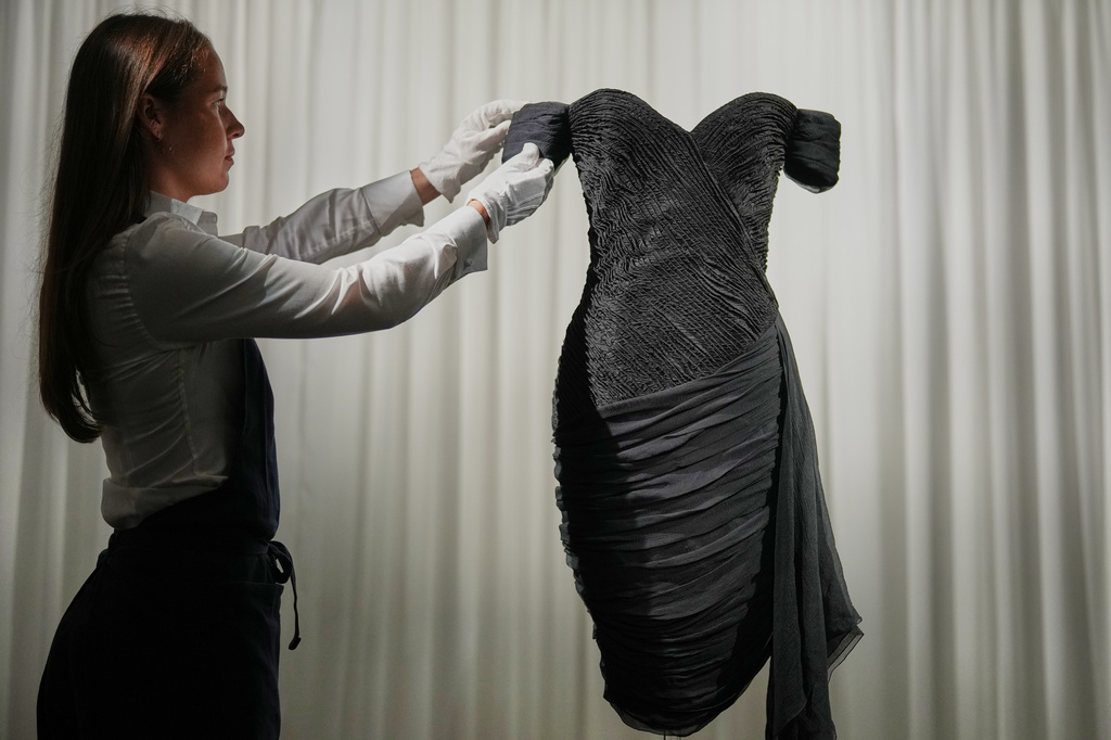 A dress worn by the late Princess Diana and known as the ''Revenge Dress'', designed by Christina Stambolian, is unveiled by staff at Sotheby’s auction house in London, Friday, Sept. 18, 2026, ahead of its Dec. 9 auction in New York, where it is estimated to sell for US$150,000-300,000. (AP Photo/Alastair Grant)