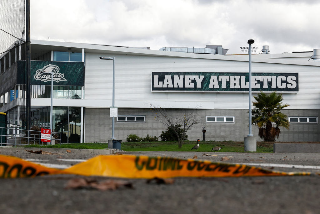 Crime scene tape lies on the ground outside of the Laney College Fieldhouse in Oakland, Calif., Friday, Nov. 14, 2025, one day after longtime Laney College athletic director John Beam was shot. (Jessica Christian/San Francisco Chronicle via AP)