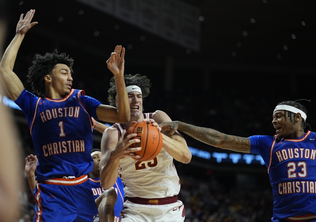 Iowa State forward Blake Buchanan (23) struggles to keep control the ball under the basket as Houston Christian guard Ryan Bartley (1) and forward Demarco Bethea (23) defend during the first half of an NCAA college basketball game, Monday, Dec. 29, 2025, in Ames, Iowa. (AP Photo/Matthew Putney)