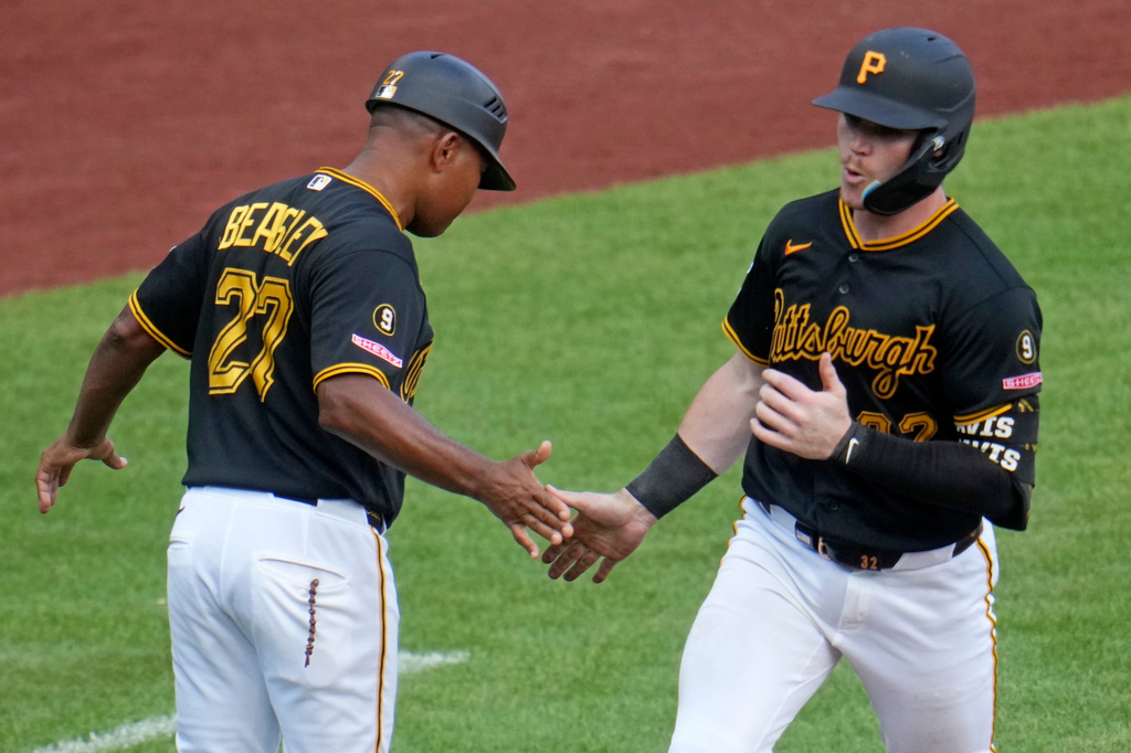 Pittsburgh Pirates' Henry Davis, right, rounds third to greetings from third base coach Tony Beasley after hitting a two-run home run off Milwaukee Brewers pitcher Aaron Ashby during the eighth inning of a baseball game in Pittsburgh, Thursday, Sept. 17, 2026. (AP Photo/Gene J. Puskar)