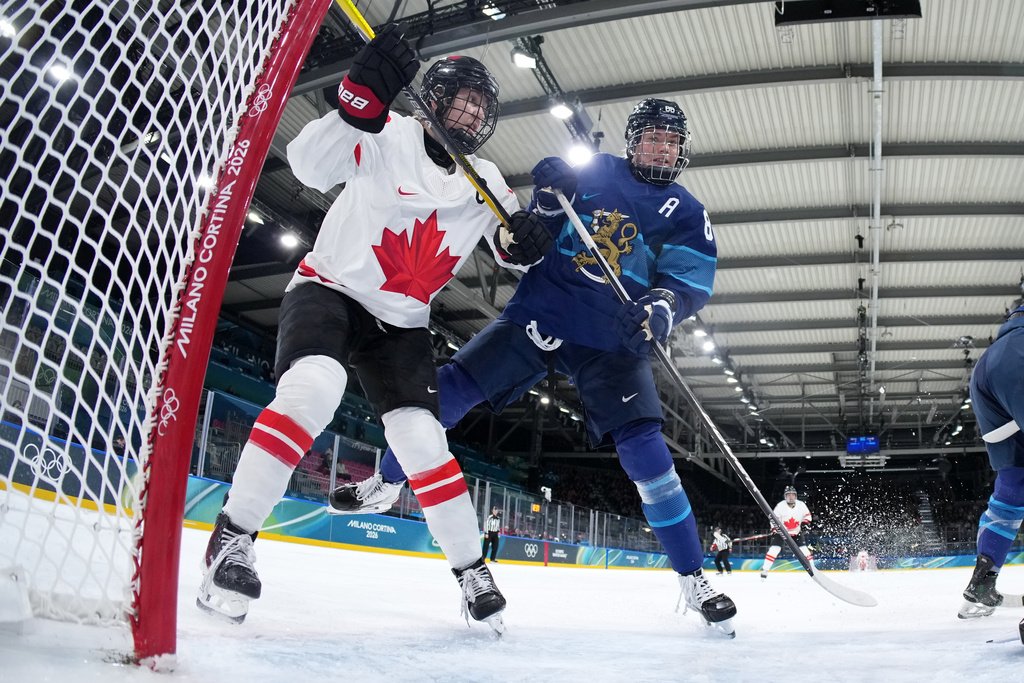 Canada's Brianne Jenner, left, challenges with Finland's Ronja Savolainen, during a preliminary round match of women's ice hockey between Finland and Canada at the 2026 Winter Olympics, in Milan, Italy, Thursday, Feb. 12, 2026. (Sun Fei/Pool Photo via AP)