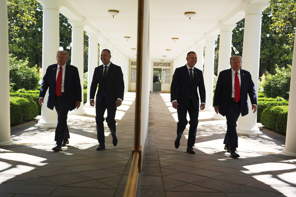 President Donald Trump and Polish President Karol Nawrocki, right, are seen reflected in the wall along the colonnade, as they walk toward an Oval Office meeting, at the White House, Wednesday, Sept. 3, 2025, in Washington. (AP Photo/Evan Vucci)