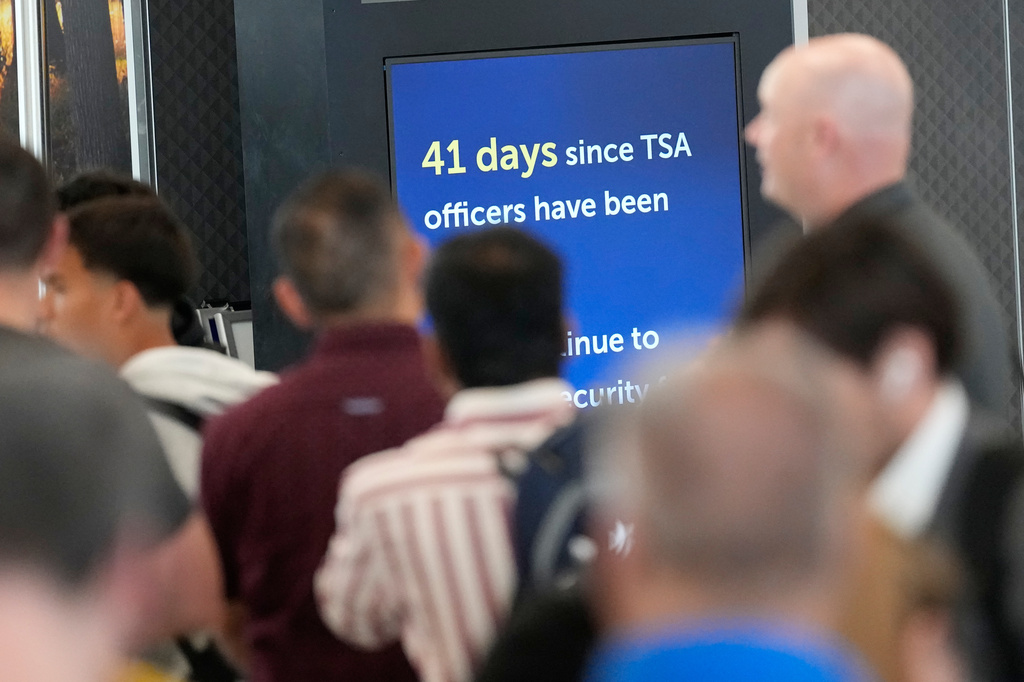 Travelers wait in long security checkpoint lines at George Bush Intercontinental Airport Friday, March 27, 2026, in Houston. (AP Photo/David J. Phillip)