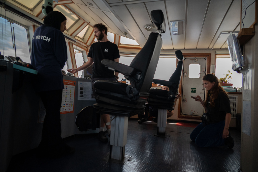 This photo released by Sea-Watch shows crew on the bridge of the migrant rescue ship Sea-Watch 5 in the Mediterranean patrolled by Libyan authorities, Monday, May 11, 2026, while, according to Sea-Watch, under attack. (Leo Spartacus/Sea-Watch via AP)