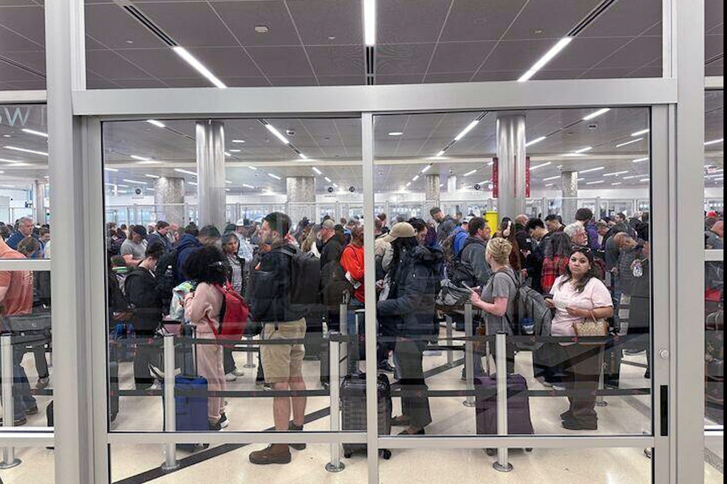 Travelers wait in line at a security checkpoint at Hartsfield-Jackson Atlanta International Airport on Monday, March 16, 2026. (AP Photo/Emilie Megnien)