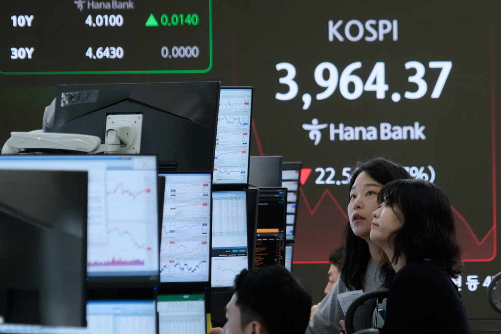 Currency traders watch monitors near a screen showing the Korea Composite Stock Price Index (KOSPI) at the foreign exchange dealing room of the Hana Bank headquarters in Seoul, South Korea, Friday, Nov. 28, 2025. (AP Photo/Ahn Young-joon)