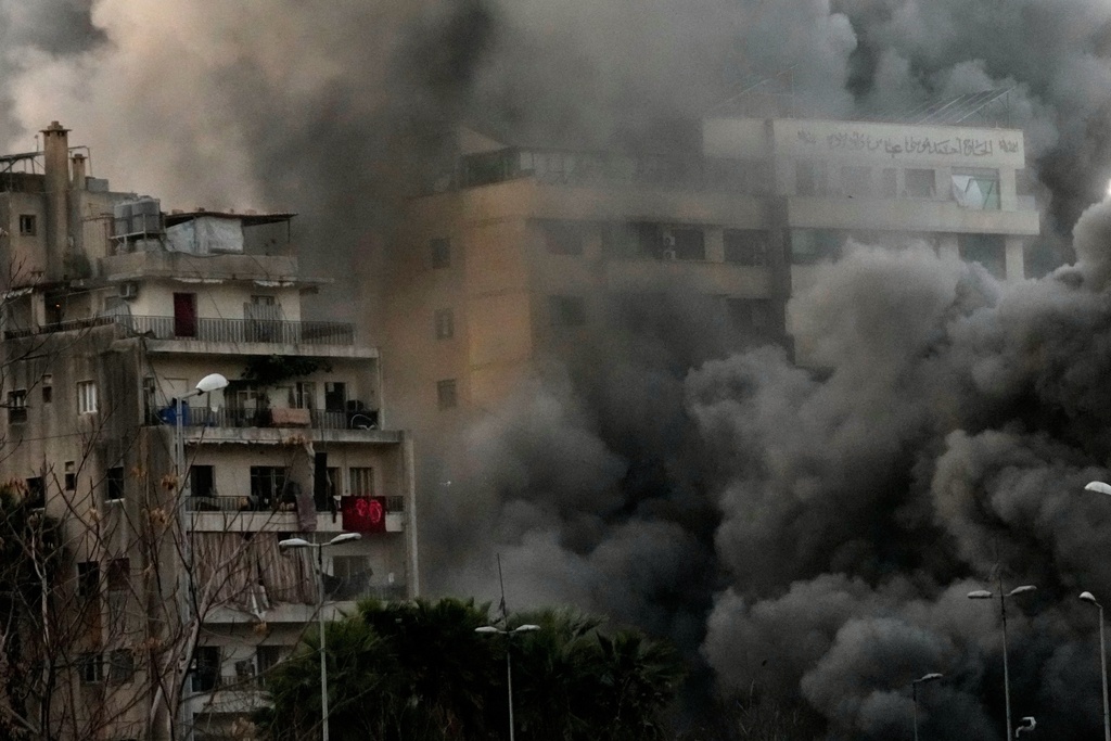 Smoke rises from a building hit by a targeted Israeli strike in central Beirut, Lebanon, Thursday, March 12, 2026. (AP Photo/Hussein Malla)