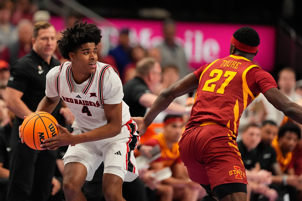 Texas Tech's Christian Anderson (4) looks to pass round Iowa State's Killyan Toure (27) during the first half of an NCAA college basketball game in the quarterfinal round of the Big 12 Conference tournament Thursday, March 12, 2026, in Kansas City, Mo. (AP Photo/Charlie Riedel)