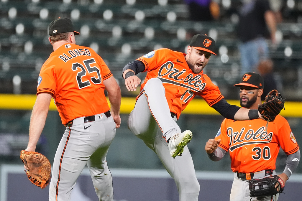 Baltimore Orioles center fielder Colton Cowser, center, celebrates with first baseman Pete Alonso, left, and right fielder Leody Taveras after defeating the Colorado Rockies in a baseball game Monday, Aug. 31, 2026, in Denver. (AP Photo/David Zalubowski)