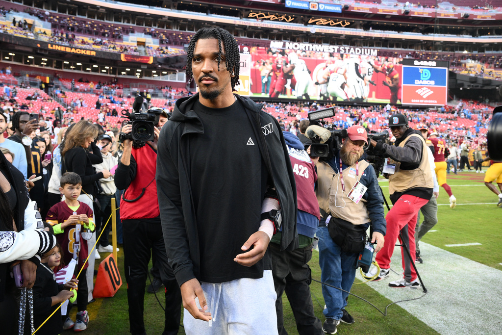 Washington Commanders quarterback Jayden Daniels (5) is seen on the sideline before an NFL football game against the Detroit Lions Sunday, Nov. 9, 2025, in Landover, Md. (AP Photo/Nick Wass)