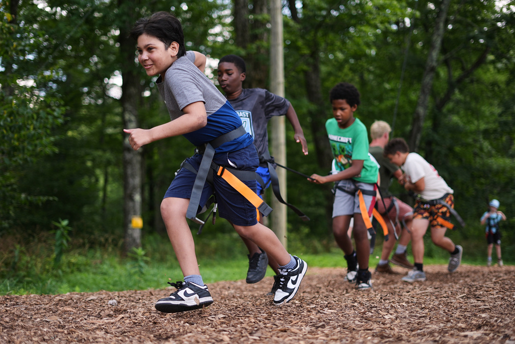 Dylan Aristy Mota, 12, left, of New York City, who has lupus, runs with fellow campers to hoist another boy into the air during an activity at the Frost Valley YMCA sleepaway camp in Claryville, N.Y., Wednesday, July 30, 2025. The camp partnered with Children's Hospital at Montefiore so kids with autoimmune diseases could attend for the first time. (AP Photo/Matt Rourke)