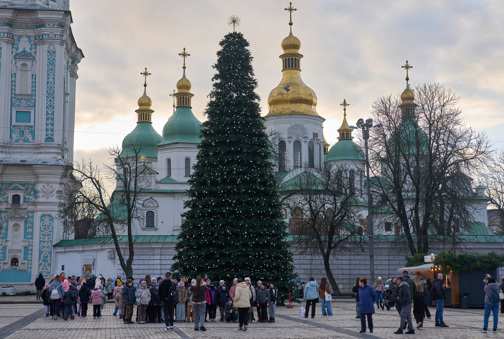 People walk around the Christmas tree in front of St. Sophia Monastery in central Kyiv, Ukraine, Wednesday, Dec. 10, 2025. (AP Photo/Efrem Lukatsky)