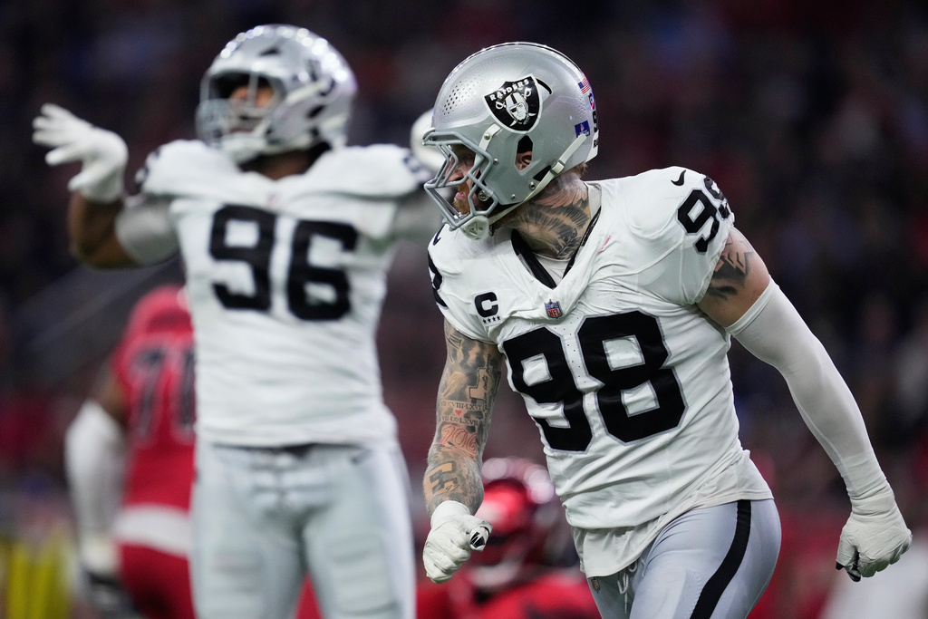 Las Vegas Raiders defensive tackle Jonah Laulu (96) and defensive end Maxx Crosby (98) celebrate during the second half of an NFL football game against the Houston Texans, Sunday, Dec. 21, 2025, in Houston. (AP Photo/Ashley Landis)